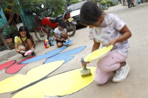 Niños pintando mariposas en la calle