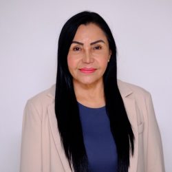 Gerente-Regional-Guaviare Gerente Regional Guaviare Retrato de estudio de una mujer con cabello largo y oscuro, piel clara, y labios rosados, vestida con un blazer color beige y una blusa azul oscuro.